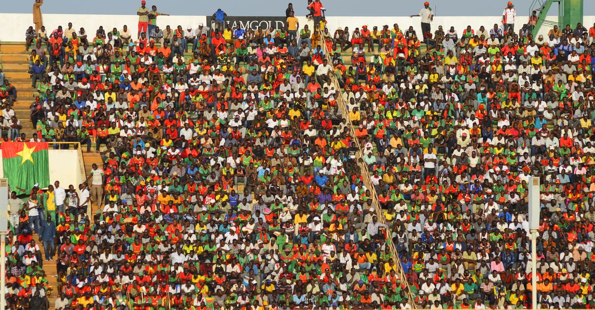 Vibrant crowd of soccer fans fills stadium seats during an exciting football match.